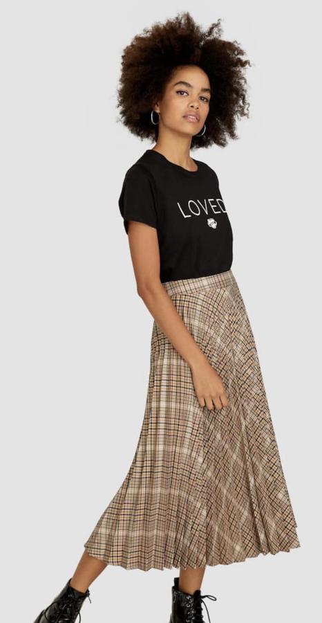 Falda plisada en color beige de Stradivarius para llevar en plano o con tacón (25,99 euros).