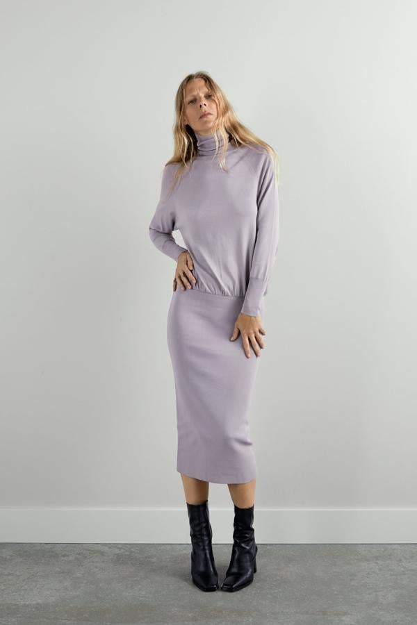 De nuevo en zara quieren darle un toque de diseño a los vestidos de punto y en este caso, han optado por un cuello de cisne y una falda más ajustada, mientras que el cuerpo queda suelo. Está en este tono gris claro y en negro (39,95 euros).