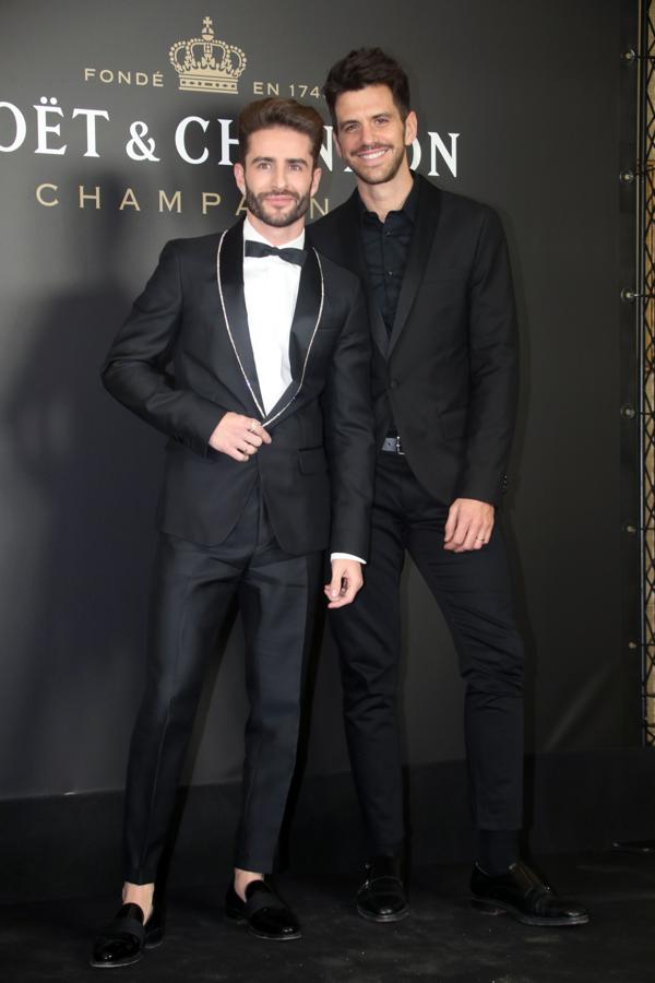 La pareja, ambos de traje muy elegantes.