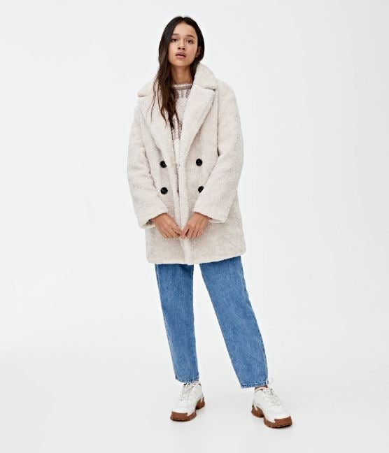 Abrigo borreguito cuatro botones  en tono blanco de Pull&Bear. (49,99 euros).