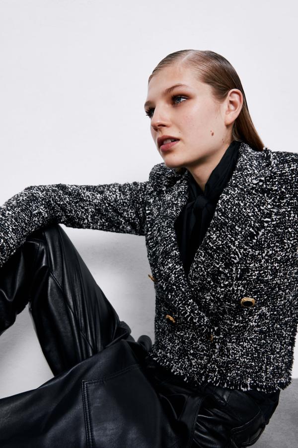 En tonos negros y grises, con botones en dorado, esta blazer cropped de Zara tiene los acabados desflecados y cuesta 69,95 euros.