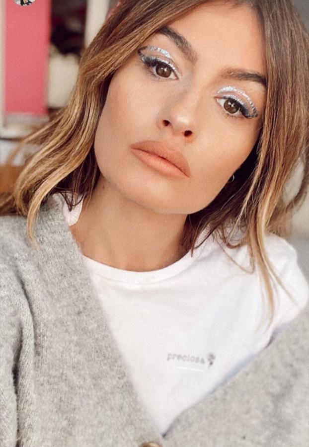 El clásico delineado negro de toda la vida esta temporada ha sido sustituido por este tipo de eyeliners con toque futurista y geométrico. En este look la influencer ha acertado de pleno combinando su estilismo en tonos neutros y grises con el plateado de sus párpados.