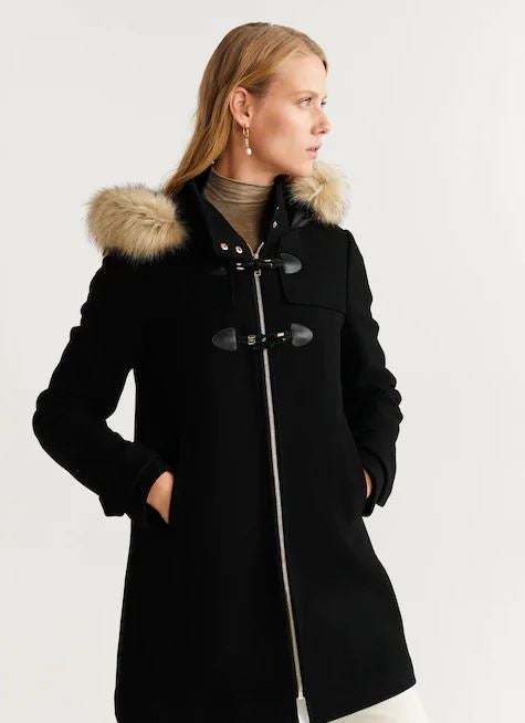 Trenca negra con cierre de cremallera y capucha de pelo. Encuéntrala en Mango. (89,99 euros).