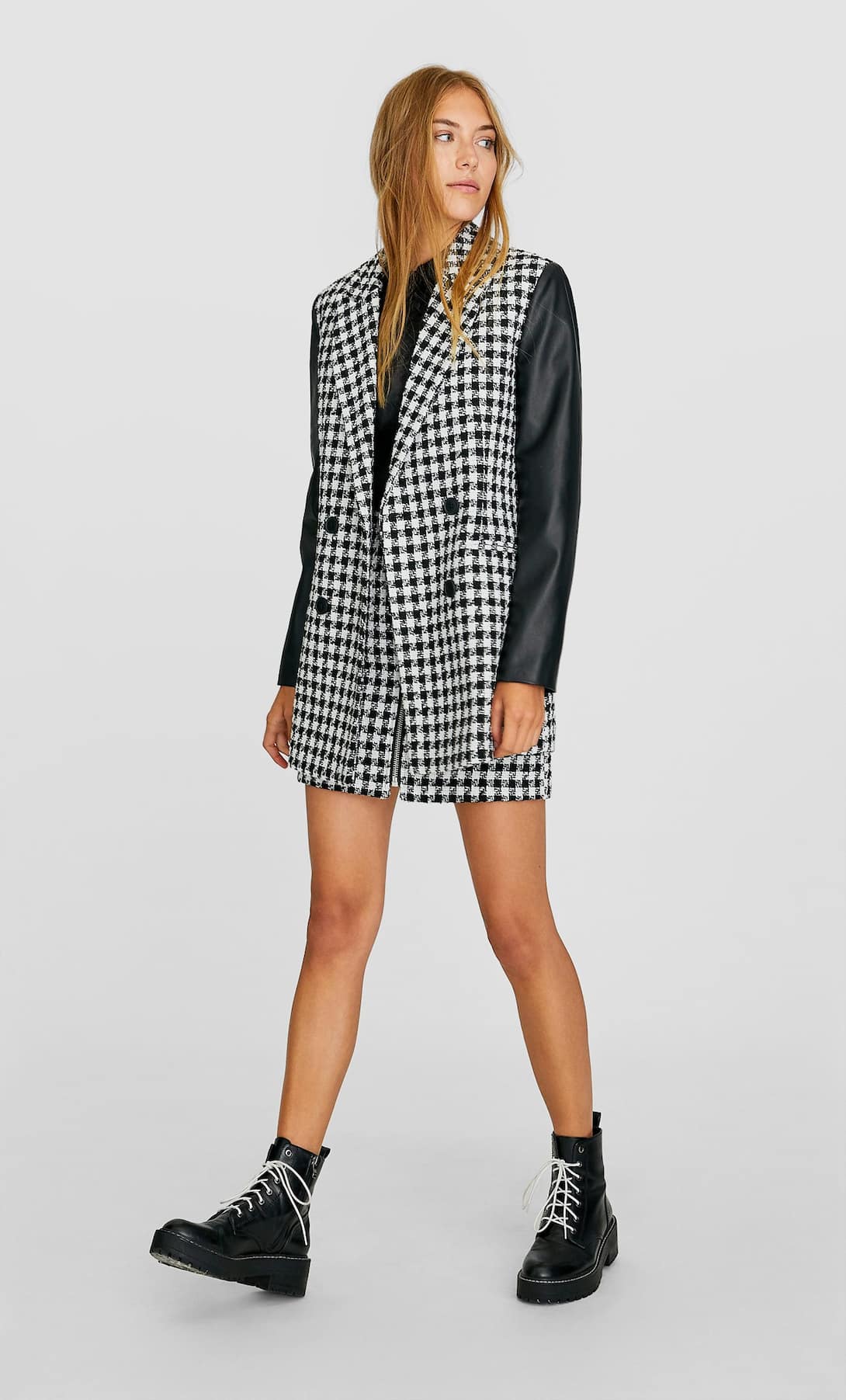 Estampado de cuadros y tejido tweed en este abrigo de tonos negros de Stradivarius. Pura tendencia. (39,99 euros).