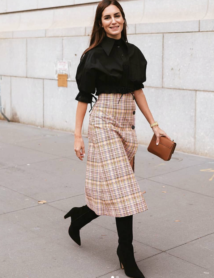 Gala González acudió a la Semana de la Moda de Madrid con la prenda más recurrente del año: la falda midi. El largo midi ha barrido absolutamente al resto, como el perfecto comodín para sustituir a los pantalones. La falda, de Carolina Herrera, lleva además una favorecedora abertura decorada con botones que alagar la silueta.La combina con camisa de mangas con volumen y botas altas, también de Carolina Herrera.