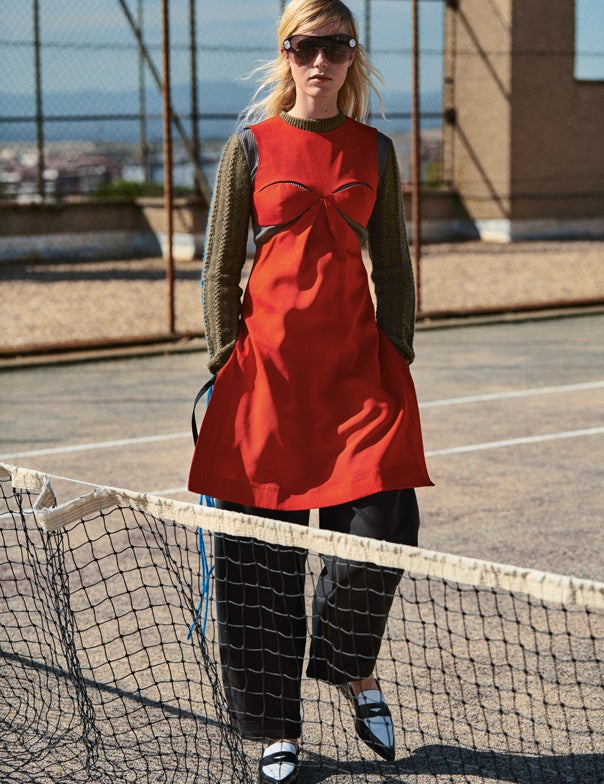 Jersey de dos texturas, vestido cut out, pantalón y mocasines bicolores, todo de Loewe. Las gafas son de Miu Miu.