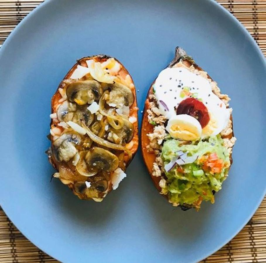 Ingredientes:-1 batata-Quesos variados al gusto-Champiñones-Cebolla-Ajo-Una pechuga de pollo-Para marinar el pollo: mostaza, tomate frito casero, soja y pimienta-Salsa de yogur: yogur, limón, ajo en polvo, pimienta y sal-Guacamole-Huevo de codorniz-Tomate cherry-SemillasPreparación:Para hacer el relleno de champiñón, en una sartén con aove hacemos cebolla y ajo, y cuando están a punto añadimos los champiñones hasta que doren.En una mitad de la batata le ponemos queso al gusto y encima los champiñones con la cebolla.Para terminar le damos un golpe de calor para que se funda el queso, y ponemos unas lascas de Grana Padano por encima.Para la otra mitad, hacemos primero el relleno de pollo. Para ello, picamos una pechuga de pollo y la dejamos macerar unos minutos con una mezcla de mostaza, tomate frito casero, soja y pimienta. A continuación lo hacemos en la sartén.También preparamos la salsa de yogur mezclándolo con sal, limón, ajo y pimienta.Lo vamos colocando encima de la otra mitad del boniato, encima el guacamole y para terminar un poco de pimiento y cebolla picado.Decoramos con un huevo de codorniz, tomate cherry y semillas.