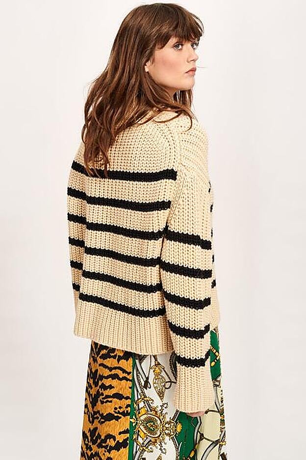 El jersey en el catçalogo de la firma belga, acompañado de una falda estampada.