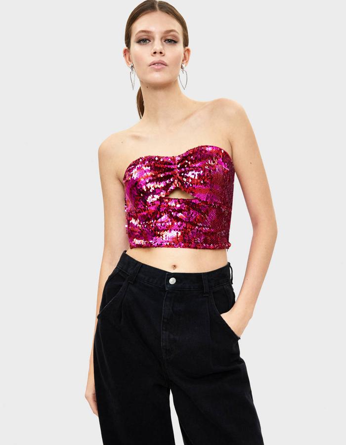 Top bandeau bordado de lentejuelas en color fucsia y con forma de lazo en el frontal (Bershka, 17,99 euros).