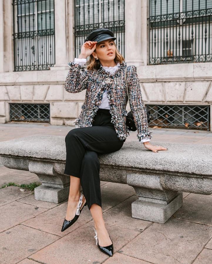 Alexandra Pereira ha conseguido uno de sus looks más sofisticados al combinar una chaqueta de tweed de colores de Chanel con un pantalón negro, camisa blanca de cuello con volante, boina negra y zapatos de Dior.