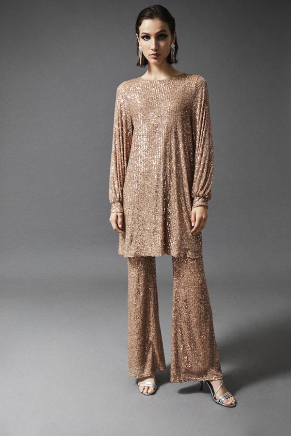 Puestas a ser la más original, este conjunto dorado de camisola y pantalón será tu mejor alido. Disimula curvas y además lo podrás reutilizar por separado (como vestido la parte de arriba y el pantalón con un blazer negra). El blusón cuesta 22,99 euros y el pantalón, 19,99.