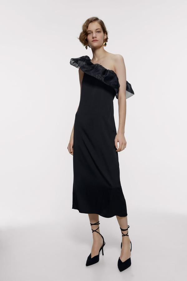 Elegante vestido negro con escote asimétrico y detalle de volante de organza de Zara (29.99 euros).
