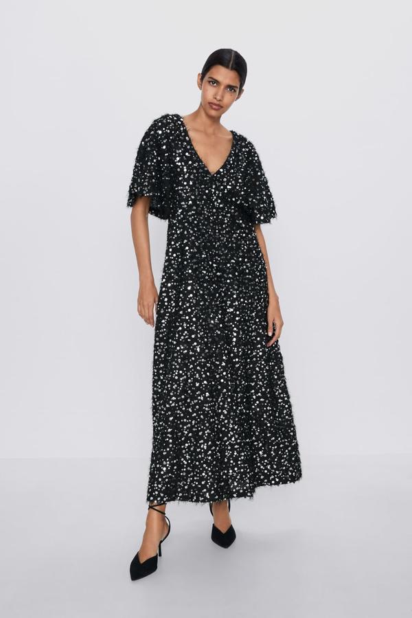 Vestido largo de lentejuelas negro de Zara con falda y mangas acampanadas (79,99 euros).