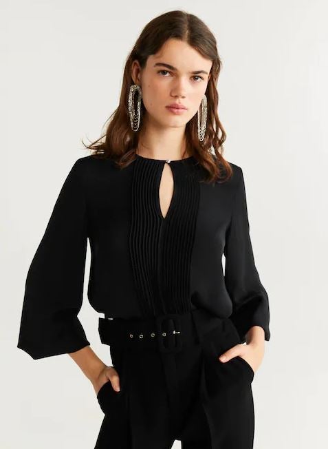Blusa cut out con detalle plisado en tono negro de Mango. (39,99 euros).