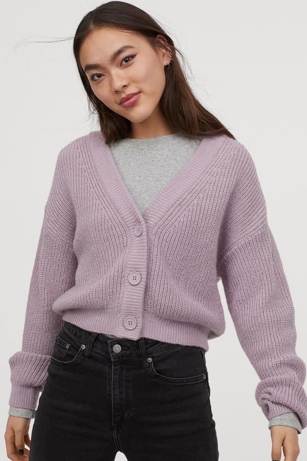El lila es uno de los tonos que, silenciosamente, se están colando en los catálogos de muchas firmas. Y aquí H&M lo utiliza para crear un cárdigan cropped ideal para nuestros estilismos otoñales, con cuello de pico u bolsillos a tono. Cuesta 19,99 euros y también está disponible en color negro, aunque solo en la web.