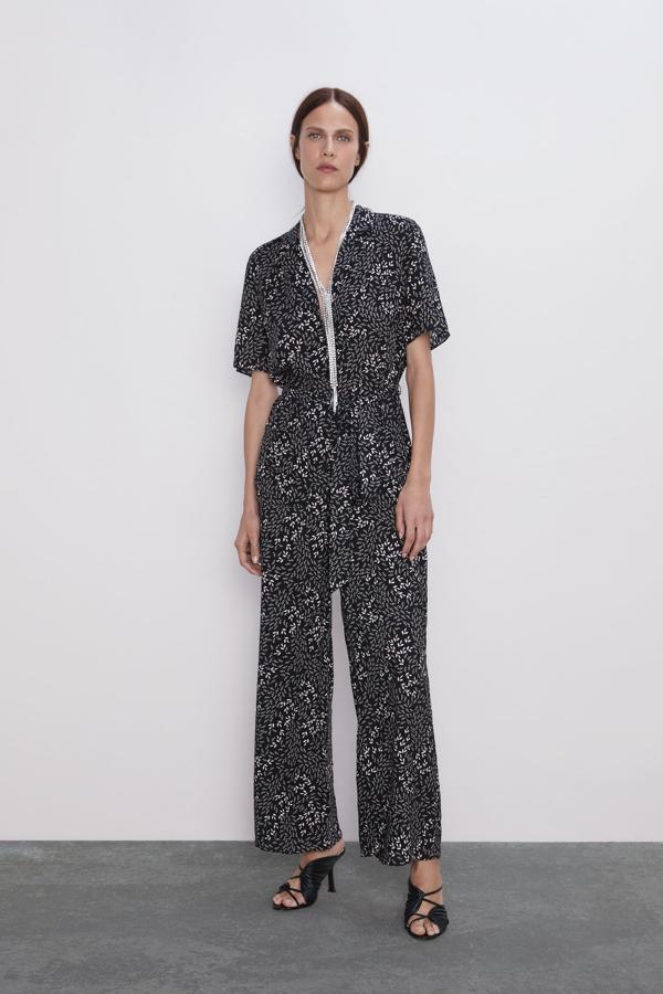 Mono de corte camisero en negro, con pequeñas flores blancas, al que le puedes añadir un collar brillante (como han hecho en la tienda de Inditex) o unos pendientes llamativos. Una sandalia joya rematará el look. Cuesta 19,99 euros.