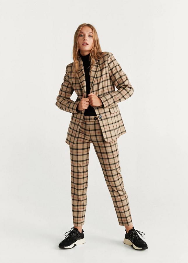 Los cuadros british se pueden llevar a una prenda de muchas formas pero nos gusta especialmente esta, que nos permite jugar con el beige y el negro en el resto de nuestro estilismo. Es de Mango y de 59,99 euros ha pasado a costar 39,99. Solo queda en la XS.