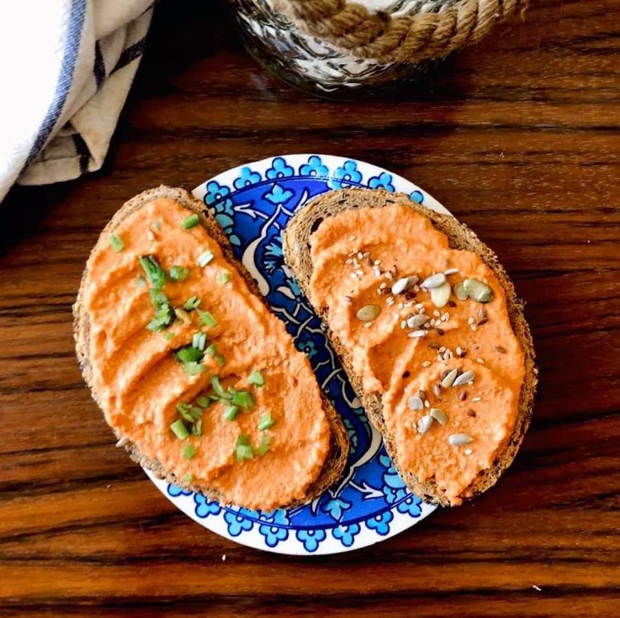 Ingredientes:1 pimiento4 dientes de ajo1/2 taza nueces1 cdta tahini o crema de anacardosPreparación:-Asamos un pimiento y una cabeza de ajo.- Ponemos el pimiento,4 dientes de ajo y media taza de nueces (puedes añadir más si lo quieres más espeso) a nuestro procesador y trituramos bien. También sirve batidora normal aunque igual llevará algo más de tiempo.- Añadimos una cucharadita de tahini o crema de anacardos para que quede algo más cremoso, ¡y listo!