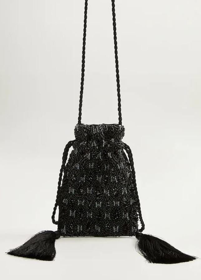 Tipo saco, en negro con abalorios que hacen pequeños dibujos y dos pompones que le dan el movimiento perfecto. Es de las rebajas de Mango: en temporada costaba 35,99 y en rebajas, 19,99 euros.