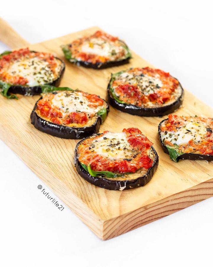 Preparación: Solo necesitas láminas finas de berenjena, rúcula, tomate frito y queso. Una pizca de orégano y al horno hasta que se doren.