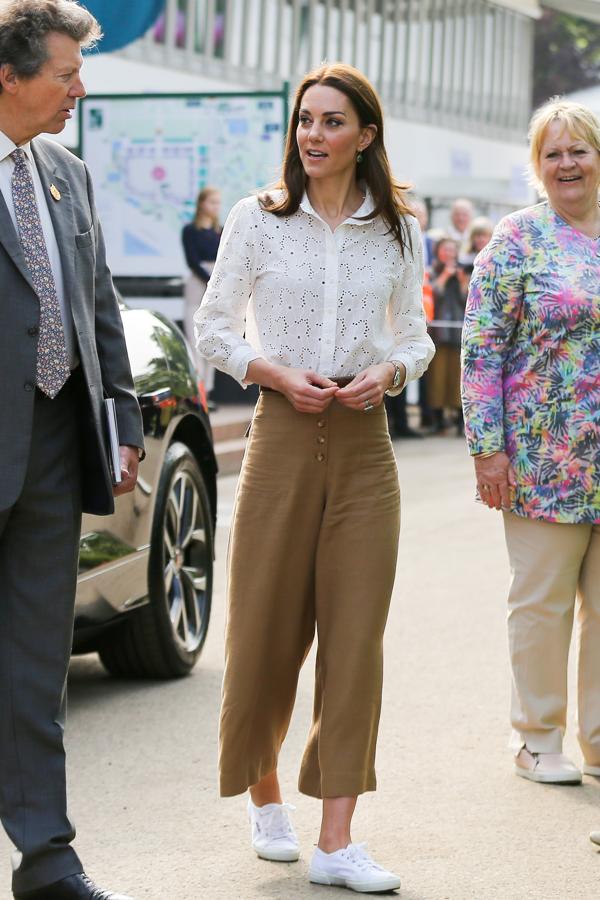 En la primavera de 2019, durante el Chelsea Flower Show, Kate Middleton volvió a conquistarnos con su versión casual gracias a este look que, además de sentar de maravilla, es de firma española: los pantalones culotte de lino son de Massimo Dutti, y quedaban perfectos con la blusa blanca calada de M.i.h. Jeans (295 euros) y unas sencillas zapatillas de lona de Superga.