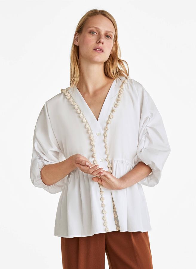 Oversize, con pompones y para llevar por fuera con cualquier color de pantalón, es de Uterqüe y se ha quedado en 49,95 euros de los 79 que costaba.