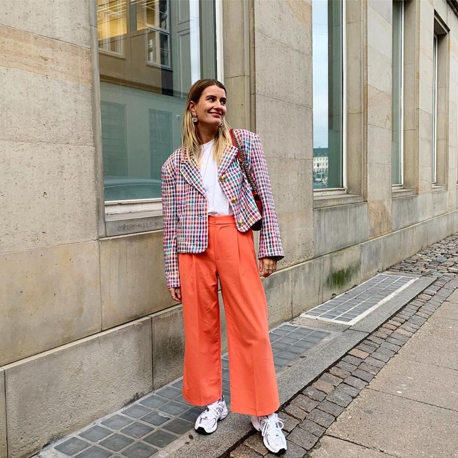 Si hay alguien que defienda estupendamente unso pantalones naranjas, esa es ella. Los lleva anchos, tobilleros y combinados con una chaqueta de cuadros multicolor. Como calzado, de nuevo unas sneakers.