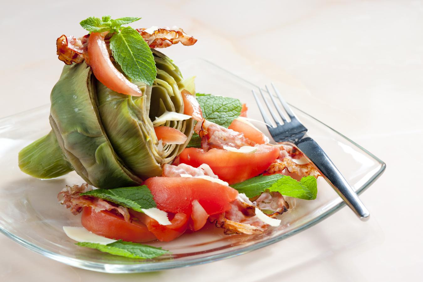 Si te encantan las alcachofas y tienes poco tiempo para cocinar, esta es tu receta. Necesitas: alcachofas hervidas, tomate, queso parmesano, bacon, unas hojas de menta y aliño al gusto.