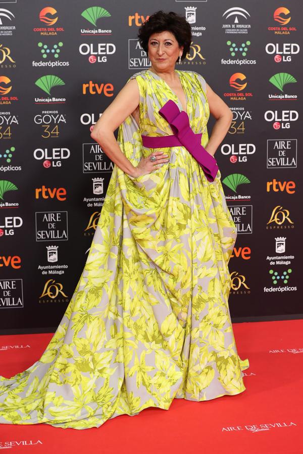 No estamos a favor de la combinación del vestido con flores amarillas llamativas con el cinturón morado con lazo ladeado.