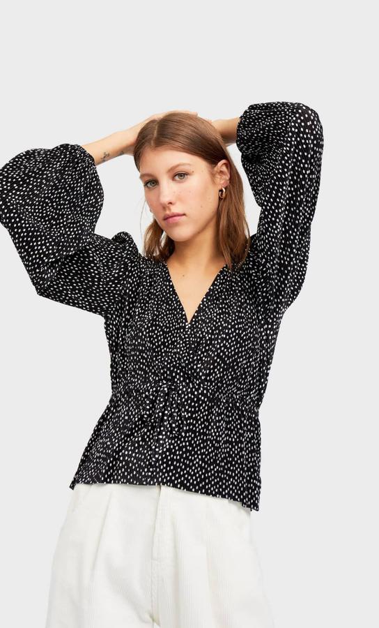 Blusa negra plisada con estampado de lunares en blanco, de la nueva colección de Stradivarius (15.99 euros).