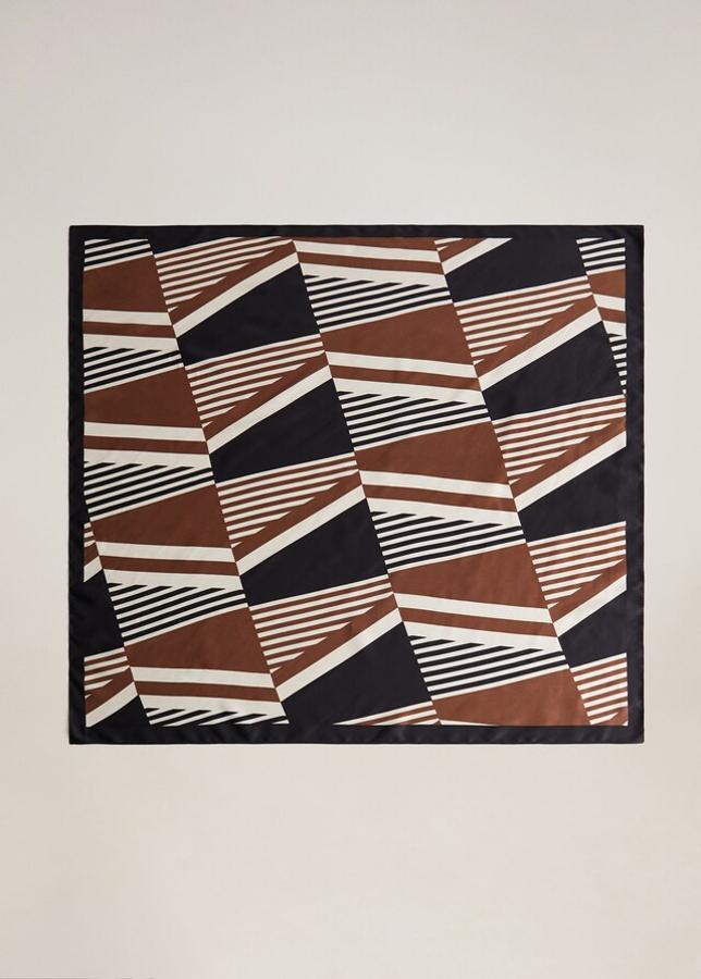 Entre nuestros diseños favoritos está este pañuelo con estampado geométrico de Mango en tonos negros, marrones y blancos. Cuesta 9,99 euros.