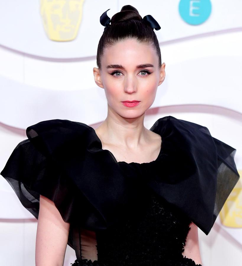 Tanto su apuesta capilar como su maquillaje desprenden feminidad a raudales. Rooney empareja un moño de bailarina, adornado con una cinta negra, con un eyeliner clásico, mejillas sonrosadas y labios rosas. Pura delicadeza.