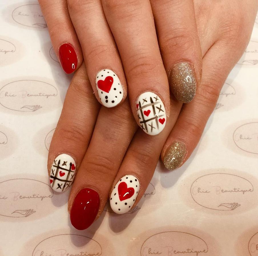 Brillos festivos, corazones y juegos de mesa en este look de uñas en el que cada una de ellas luce un motivo o un color diferente. Si la paciencia nos acompañase, escogeríamos este sin dudarlo.