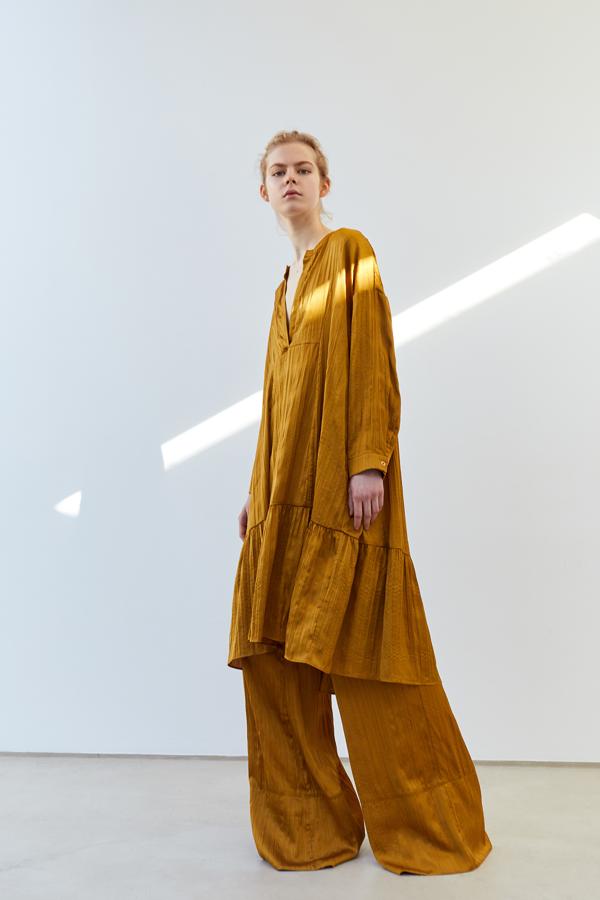 Vestido midi de tejido plisado en un tono mostaza oscuro, de la nueva colección de Sfera (35,99 euros).