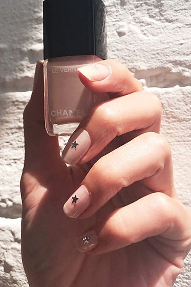 Sencillez máxima: manicura francesa con una estrella en el centro.