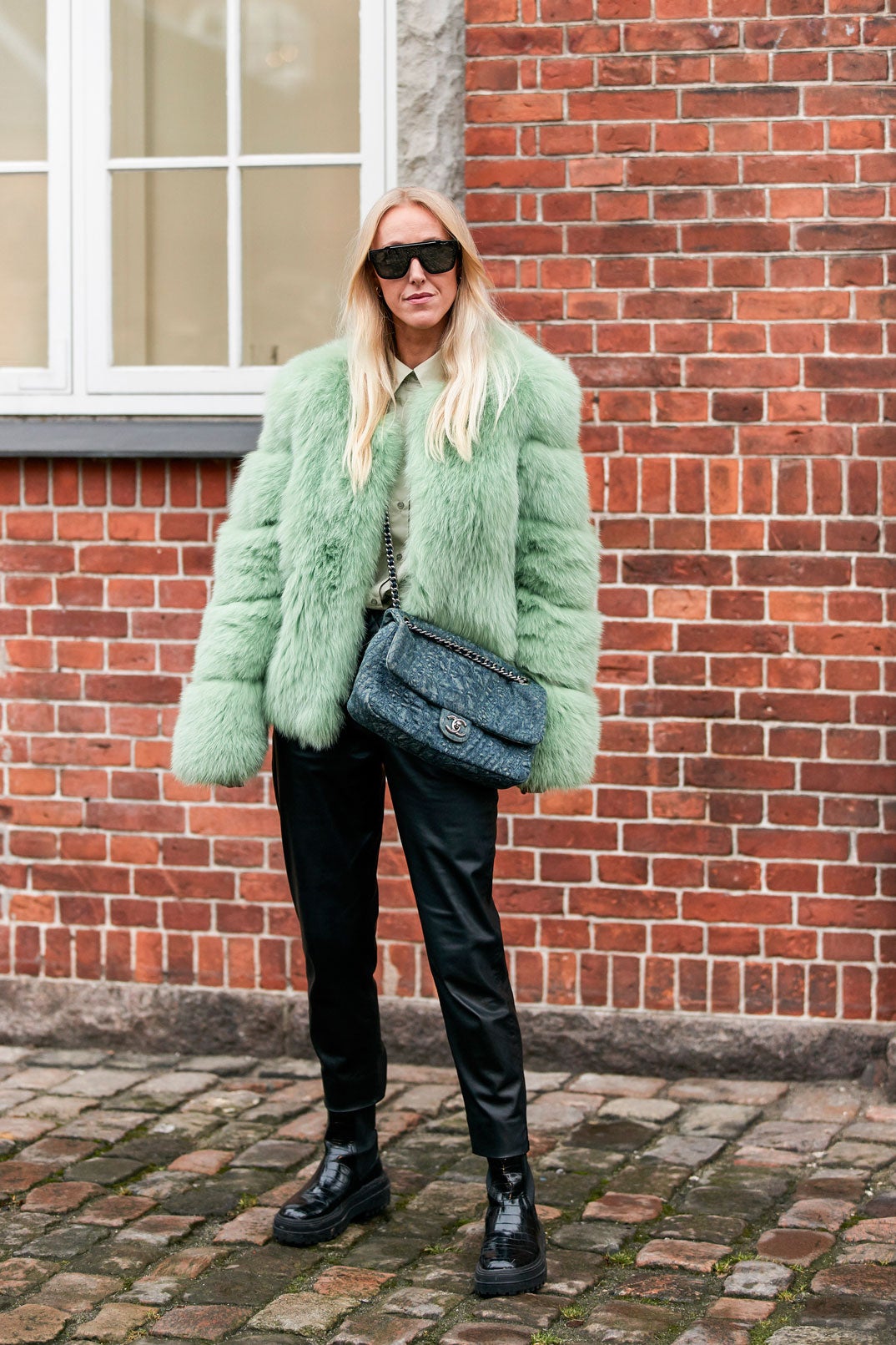 Look bicolor: blusa y abrigo de pelo en tonos verde pastel con pantalones y botas negras. ¡Todo un acierto!