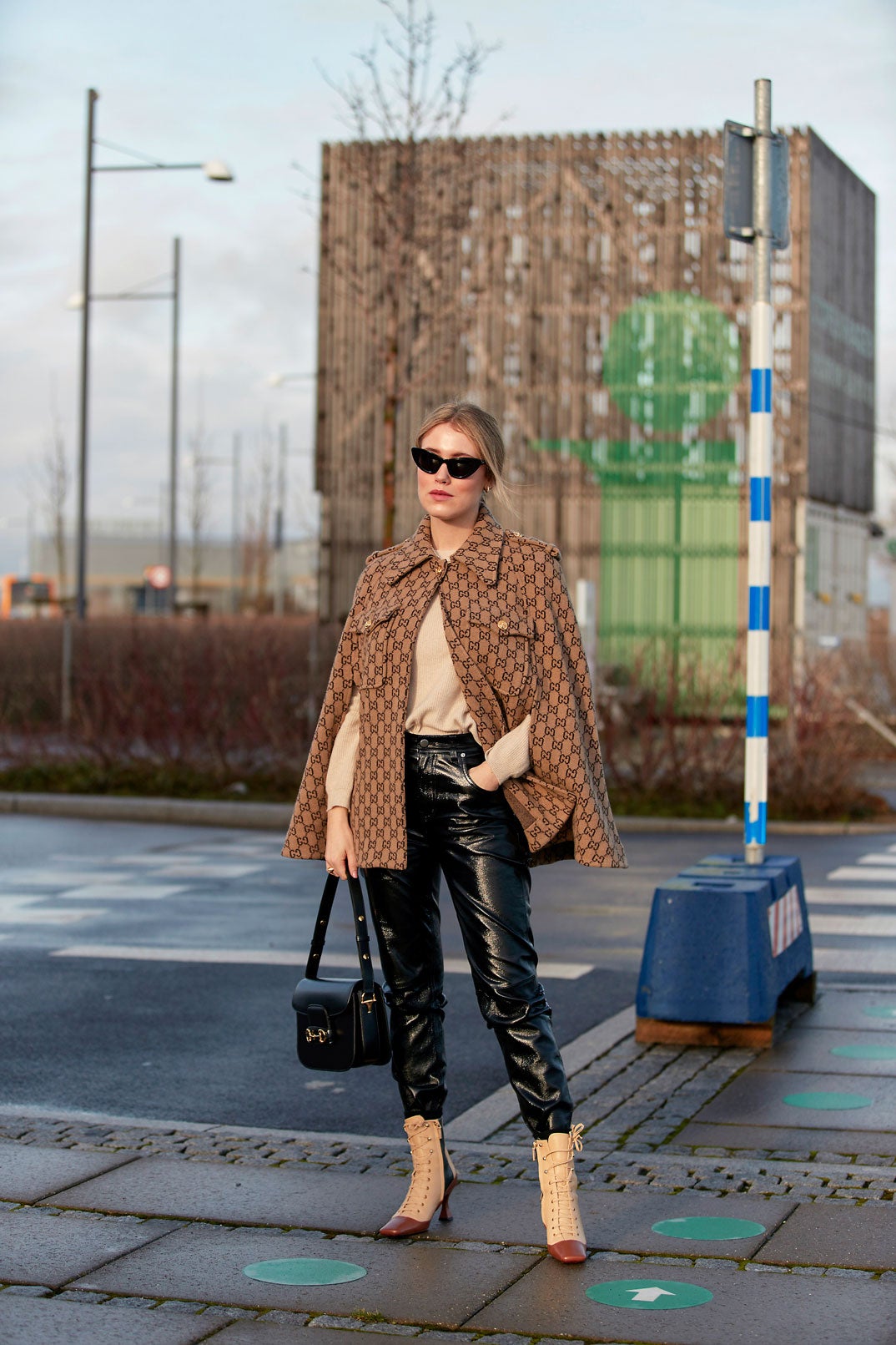 Los tonos marrones y beige de esta capa de lana de Gucci con el jersey de punto en color vainilla a juego con los botines acordonados rompen con la estética más rock de los pantalones efecto piel. ¡Y nos encanta!