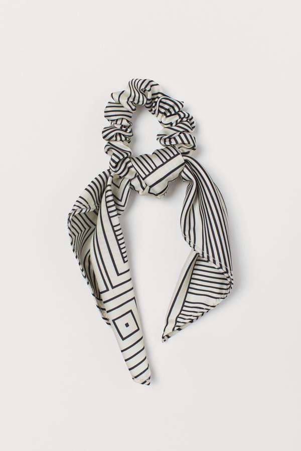 Formas geométricas sobre fondo blanco para este elegante coletero con pañuelo acabado en pico. Cuesta 4,99 euros.