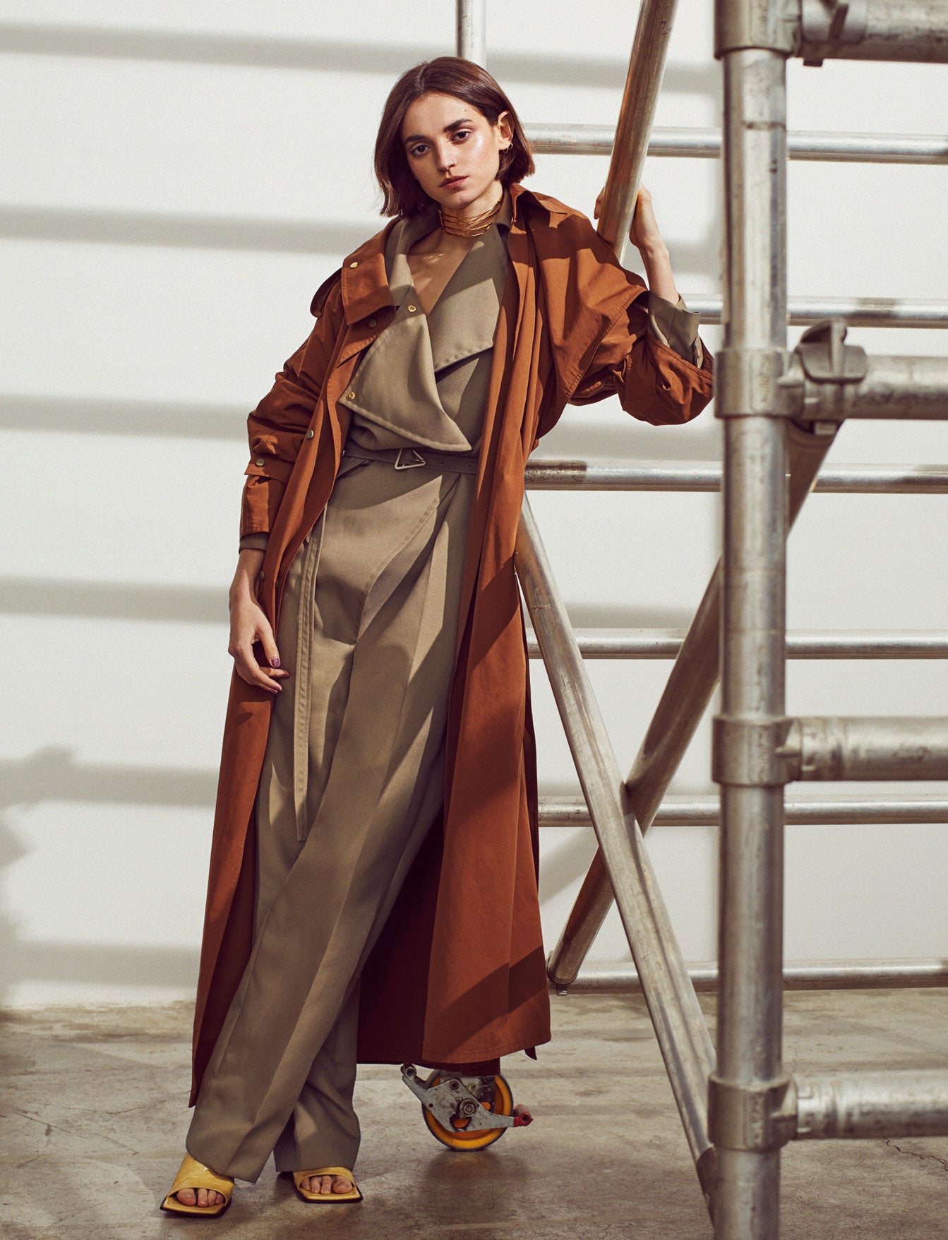 Gabardina, mono y sandalias, todo de Bottega Veneta. El collar es de Suma Cruz.