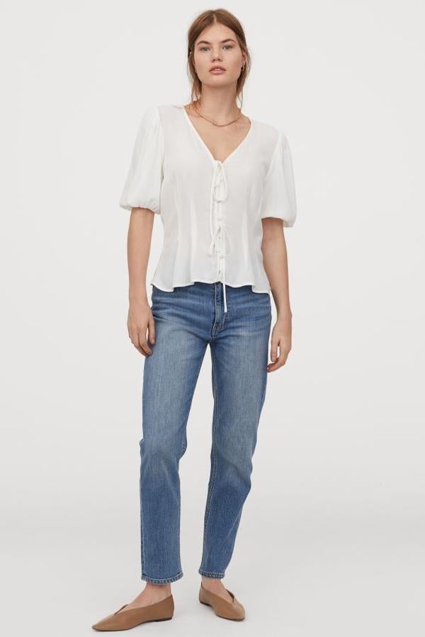 Otro de los diseños que H&M vende exclusivamente en su web esta blusa en tejido crepé con escote de pico, tiras finas de anudar y botones revestidos delanteros. Las mangas abullonadas son de doble capa, y tiene bajo asimétrico. Cuesta 14,99 euros y está disponible entre las tallas 32 y 50.