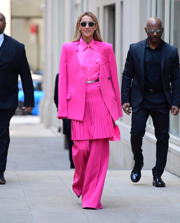 ¿La reina del street style? Céline Dion demuestra que es ella con este look fucsia de Peter Do formado por un traje de falda plisada, pantalón flare, blazer sin solapara y camisa.