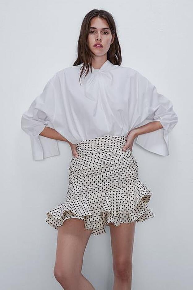 Zara nos propone la falda de lunares y volantes con una camisa blanca en vez de negra, como lleva Mery Turiel.