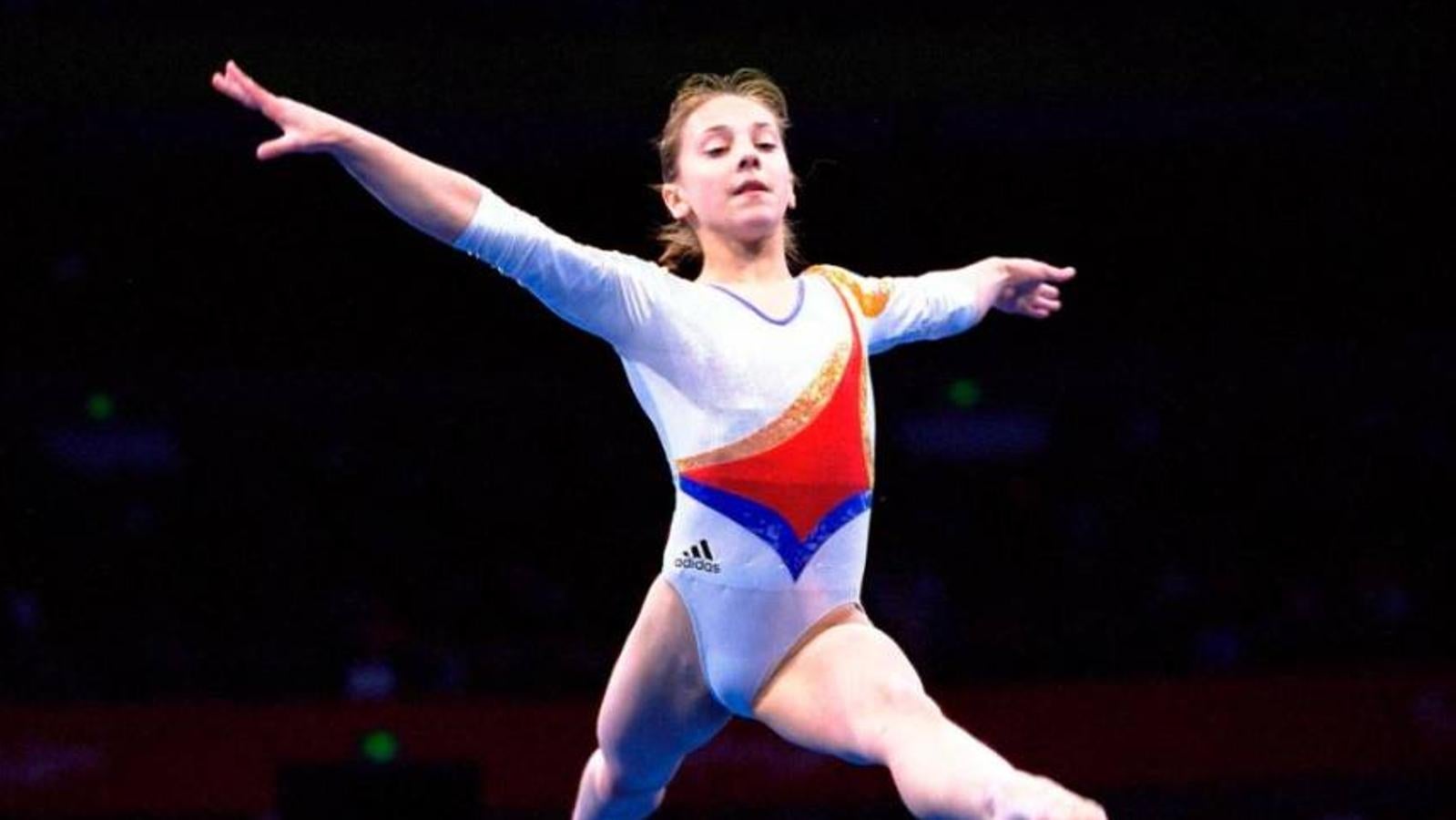 Ya puedes ver en HBO este documental que narra la vida de Andreea Răducan, una exitosa mujer de 32 años que fue una de las mejores gimnastas de Rumania. Sacrificó su infancia para convertirse en campeona olímpica y, cuando finalmente ganó la medalla de oro en Sydney en 2000, fue despojada de ella tras dar positivo en un control antidopaje por una sustancia encontrada en una tableta contra la gripe que su médico le había administrado unos minutos antes de empezar a competir. Quince años después, Andreea está batiendo la lucha más dura de su vida contra las personas que la engañaron, mientras trata de recuperar su medalla y, junto con ella, su dignidad. Por el camino, el documental descubre el otro lado de la medalla, el trauma y el esfuerzo, el sudor y el dolor que hay detrás del brillo de una medalla de oro y el glamour de ser campeona.