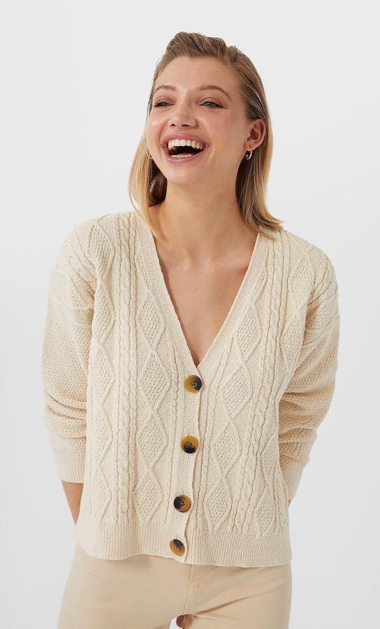 Diseño trenzado para este cárdigan en color vainilla con botones en tonos marrones y negros. Cuesta 25,99 euros y está disponible entre las tallas XS y M.