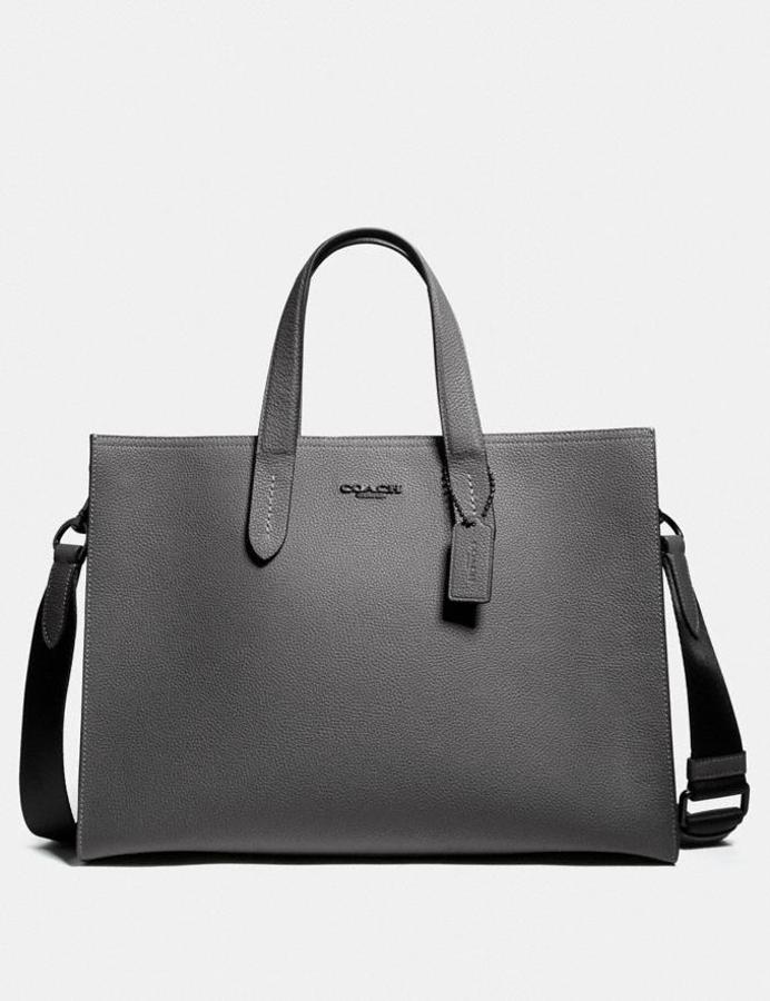 Minimalista y de piel granulada pulida, el maletín Charlie de Coach tiene espacio para un portátil de 13” y sin duda será el foco de todas las miradas si llegas a una reunión con él. Nos quedamos con el modelo en color gris (550€).