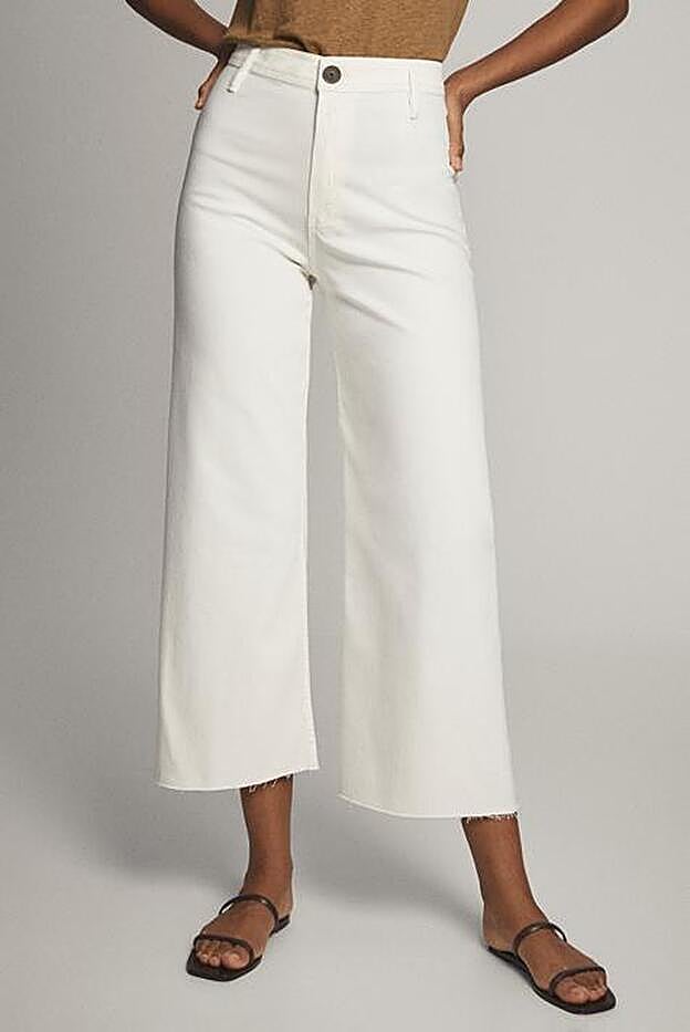 Puedes combinar la blusa de estampado de palmeras con unos vaqueros blancos de corte culotte como estos.