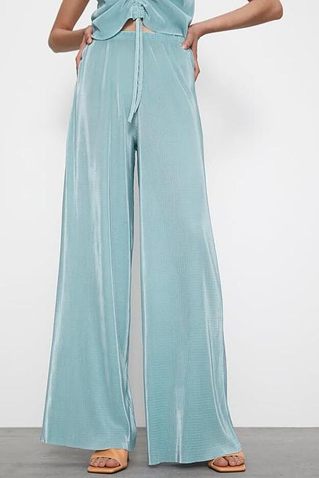 Un pantalón plisado y fluido de color azul agua de Zara.