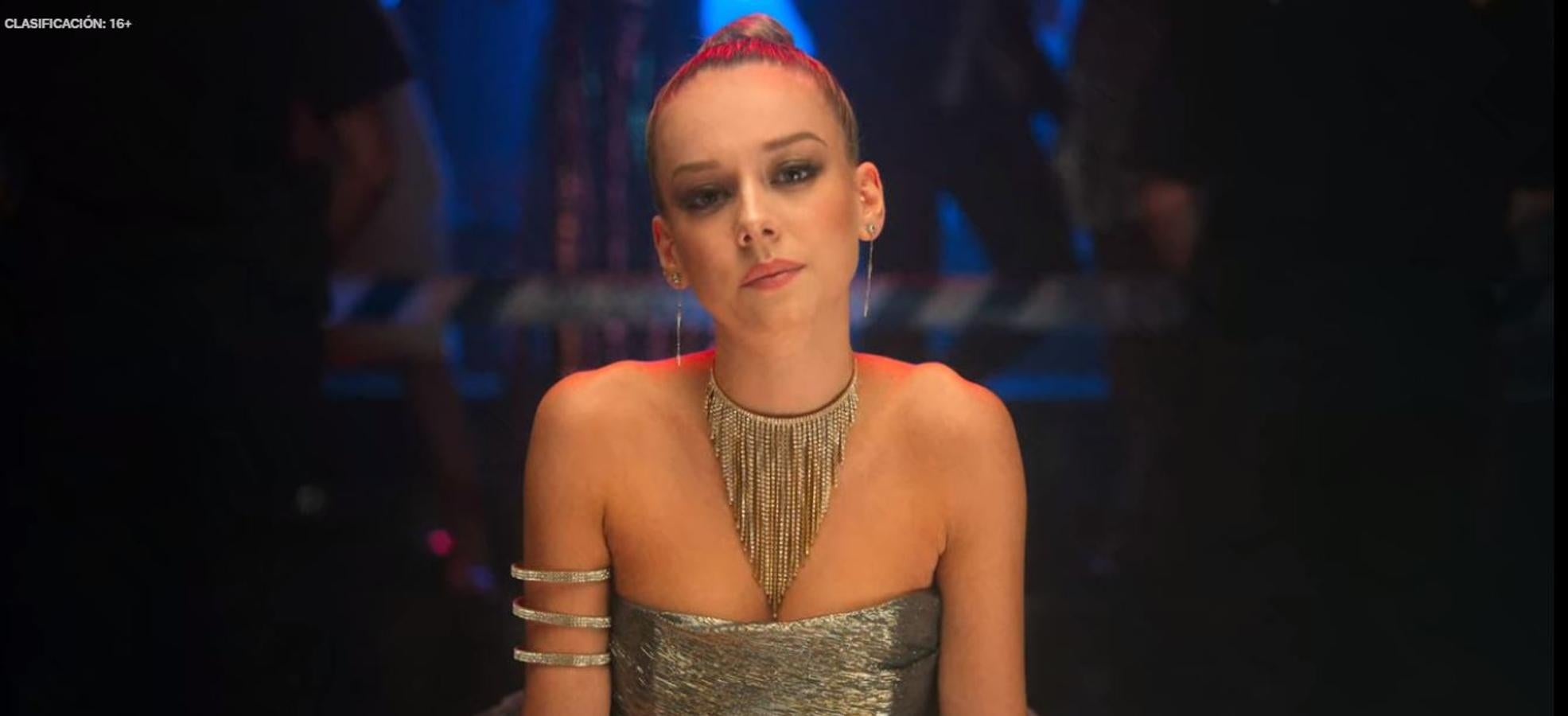 En una de las fiestas a las que acude el personaje de Ester Expósito, la actriz acompaña su recogido alto con un make-up que tiene como protagonista la sombra oscura de los ojos, potenciando así la mirada.