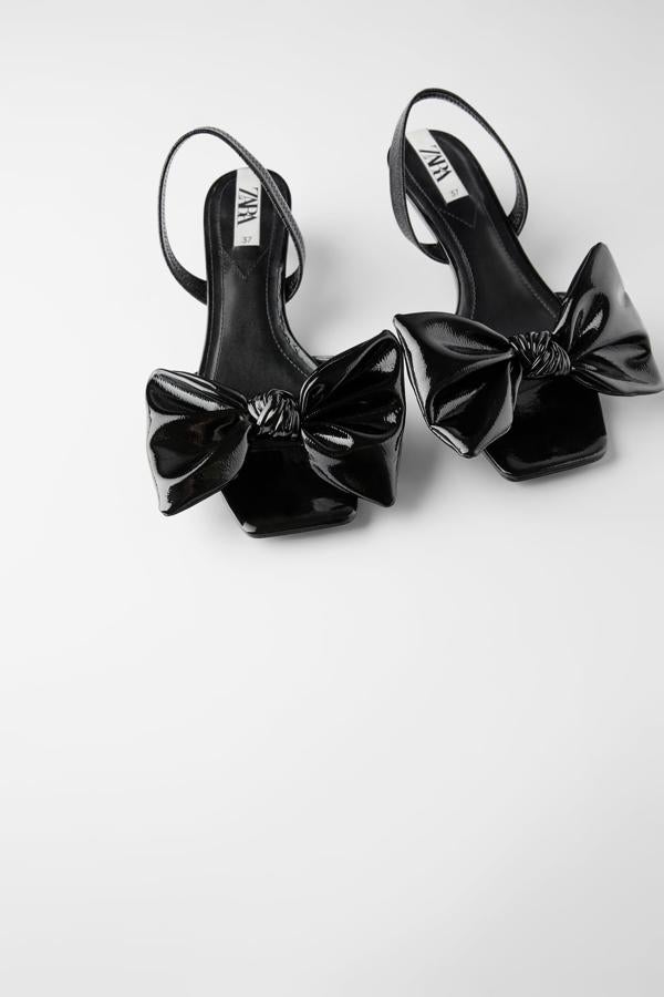 Dos preciosos lazos, tipo pajarita, son los protagonistas de estas sandalias de tacón kitten cuadrado acabadas en charol de Zara. Tienen tira elástica trasera y acaban en punta cuadrada. Cuestan 35,95 euros y están disponibles entre los números 35 y 39.