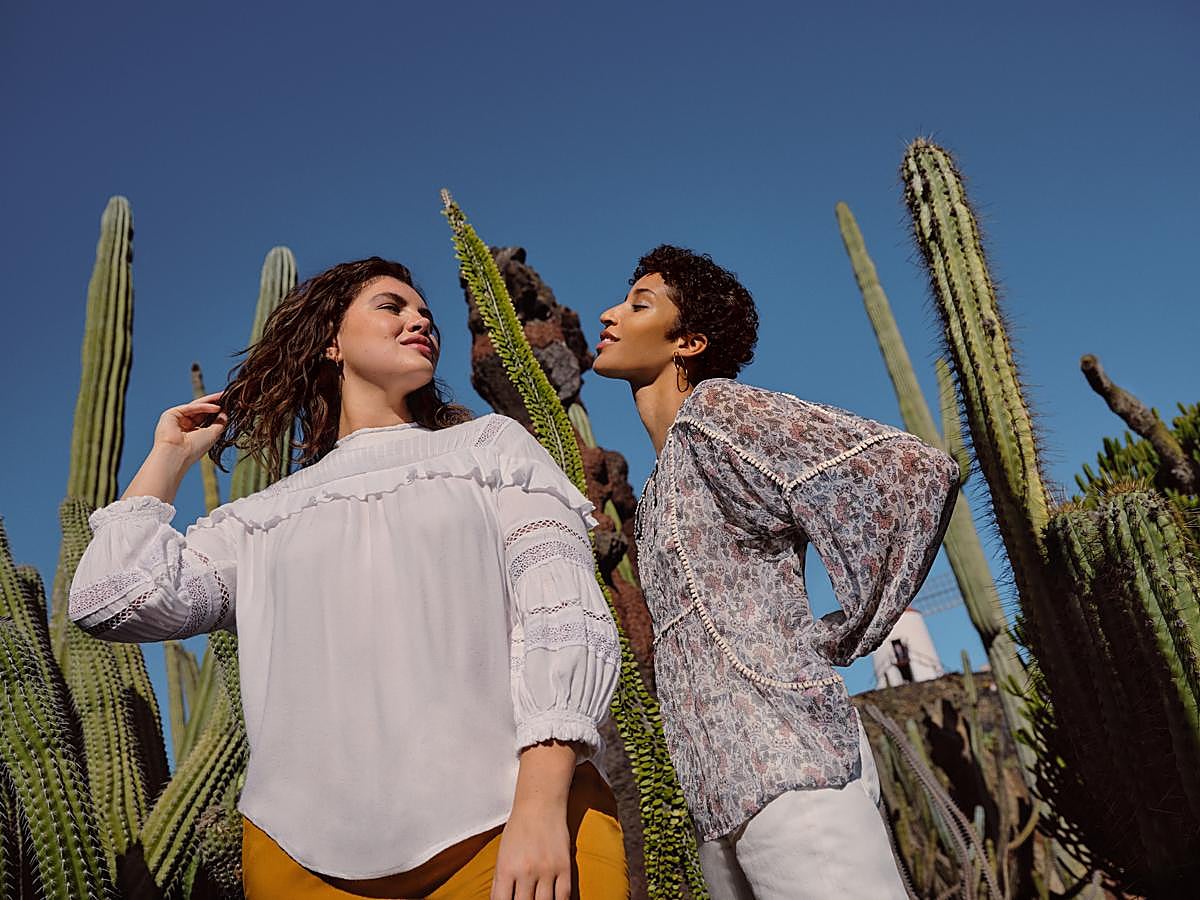 Blusa blanca con adornos de encaje en las magas y volantes en el escote y blusa fluida de estampado de flores.